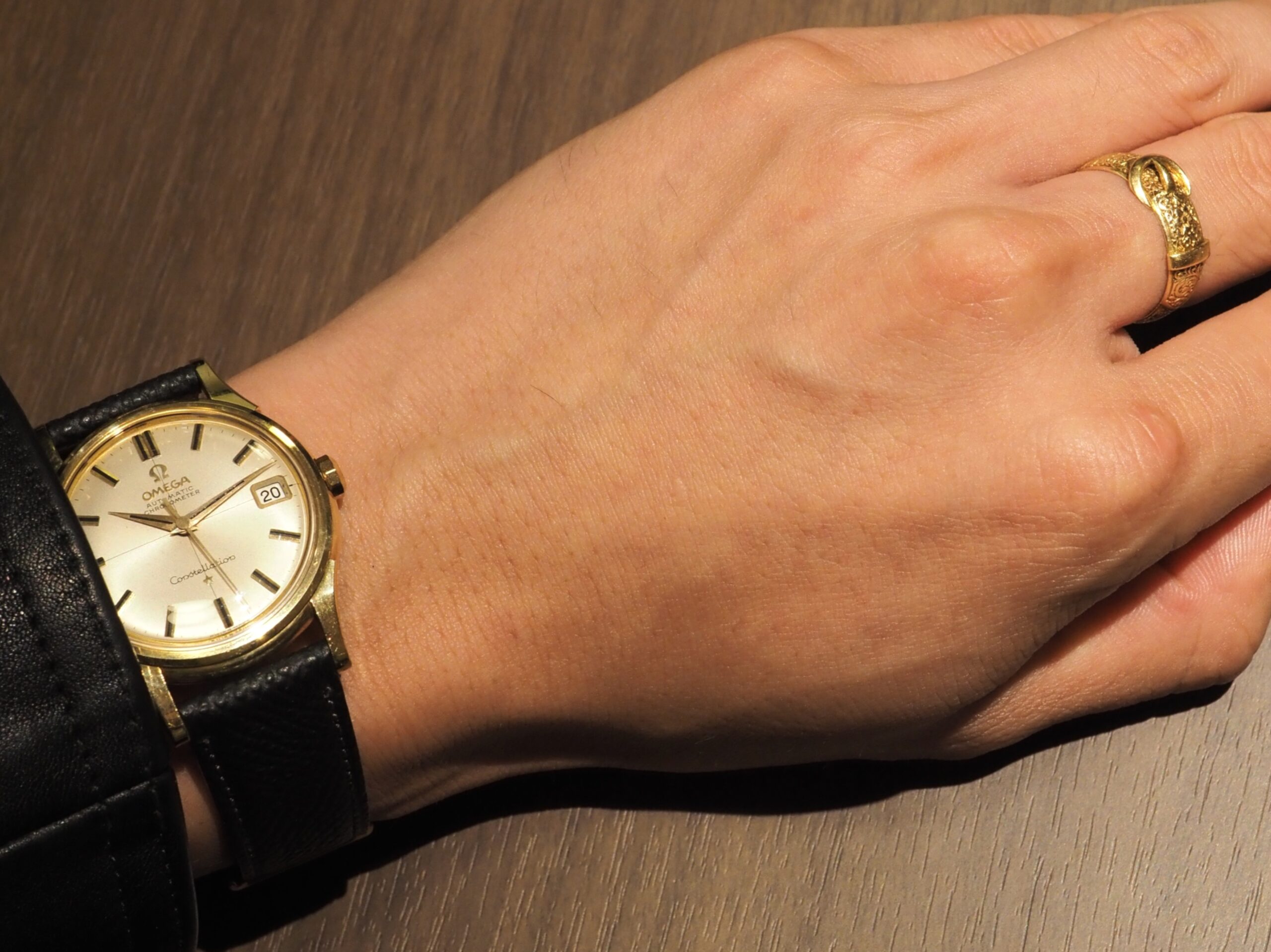 1960年代オメガ(OMEGA)コンステレーションの金無垢アンティーク時計と、中指のバックルリングが手元を彩るメンズコーディネート